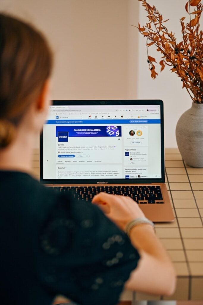Woman using a laptop with social media open