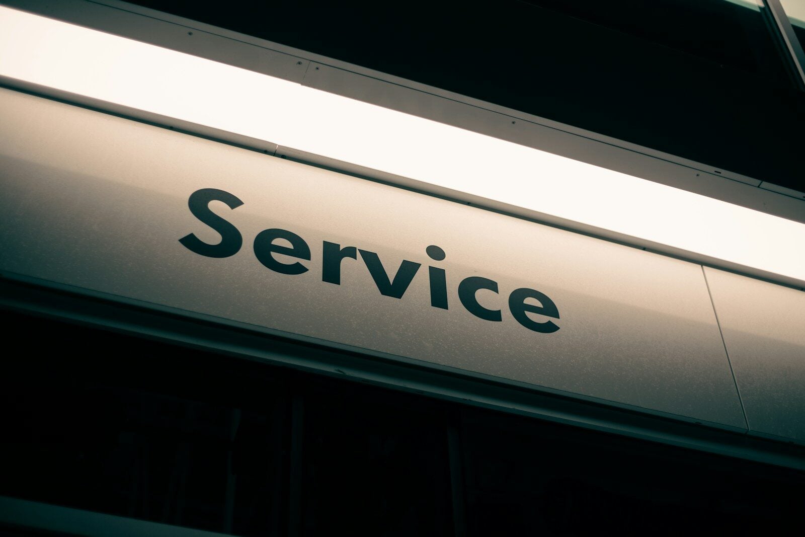 A sign with the word Service in black letters on a white background